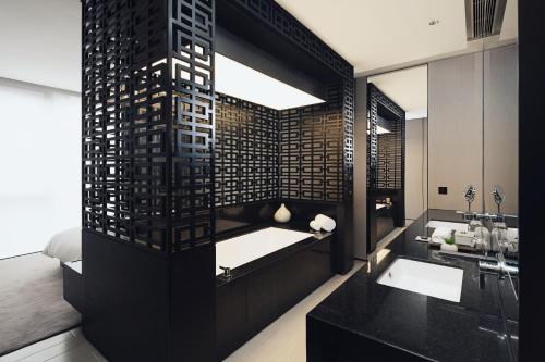 a bathroom with a sink and a large mirror at The Temple House in Chengdu