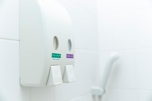 a soap dispenser on a wall in a bathroom at Saga Idaimae Green Hotel in Saga