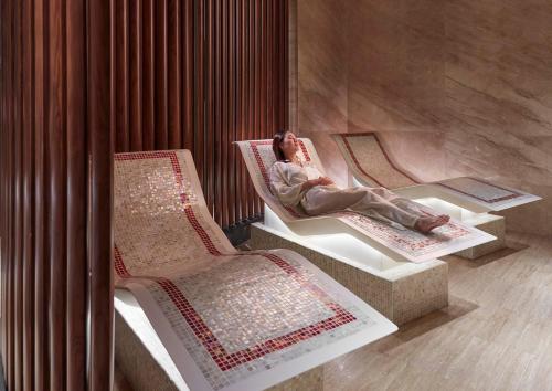 a woman is sitting on a chair in a room at Mandarin Oriental, Hong Kong in Hong Kong