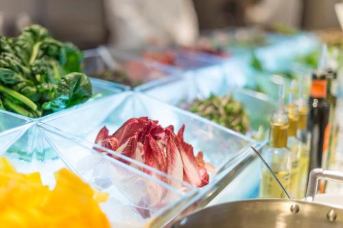 a table topped with a bowl of food and vegetables at ANA Crowne Plaza Akita by IHG in Akita