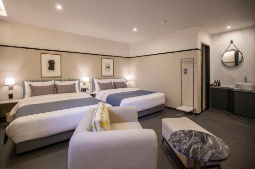 a hotel room with two beds and a couch at Browndot Hotel Masan Odong in Changwon