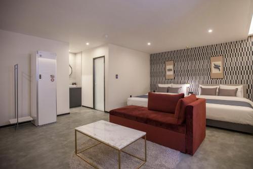a hotel room with a bed and a couch and a chair at Browndot Hotel Masan Odong in Changwon