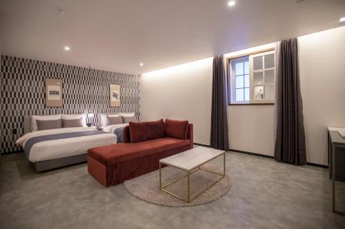 a hotel room with a bed and a couch and a chair at Browndot Hotel Masan Odong in Changwon