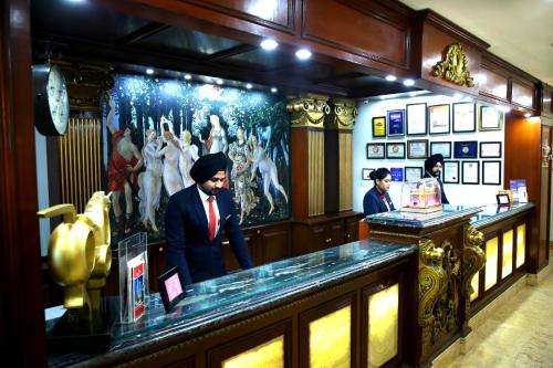 a man standing behind a counter in a restaurant at Ramada By Wyndham Amritsar in Amritsar