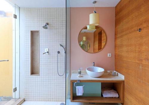 a bathroom with a sink and a shower with a mirror at Bay Terraces Beach View - Vasco Da Gama by StayVista in Marmagao