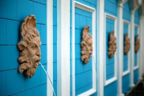 a face gargoyle on the side of a blue building at Ramada By Wyndham Amritsar in Amritsar