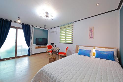 a bedroom with a bed and a table and chairs at Yejeon Pension in Gyeongju