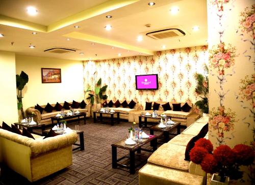 a waiting room with couches and tables and a tv at Ramada By Wyndham Amritsar in Amritsar