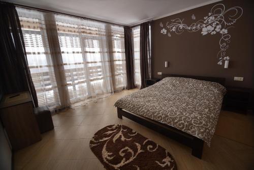sypialnia z łóżkiem, oknem i dywanem w obiekcie Ozone minihotel w mieście Jabłonica