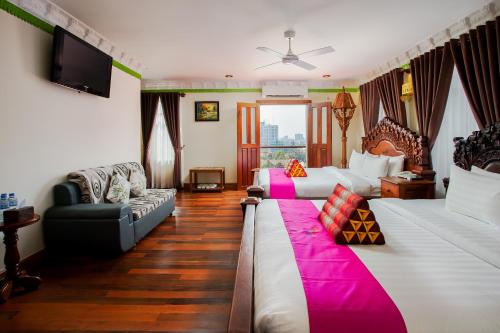a living room with two beds and a couch at Okay Palace Hotel in Phnom Penh