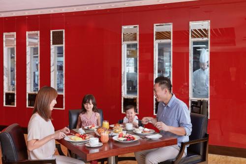 a group of people sitting at a table eating food at Mandarin Oriental, Hong Kong in Hong Kong