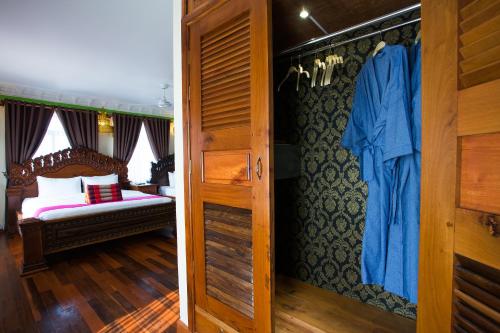 a bedroom with a bed and a room with a closet at Okay Palace Hotel in Phnom Penh