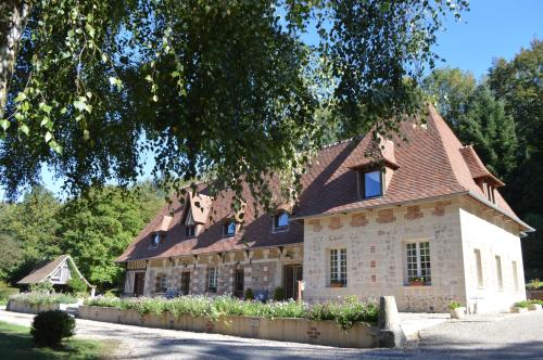 a large stone house with a brown roof at Le prieuré des fontaines in Les Préaux