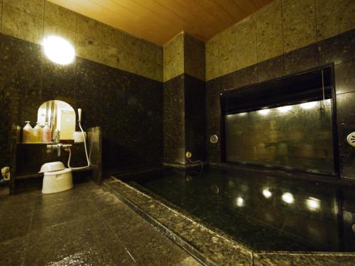 uma casa de banho com uma banheira e um WC. em Hotel Route-Inn Tosu Ekimae em Tosu