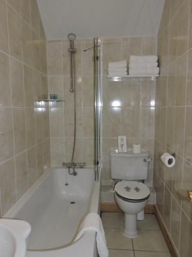 a bathroom with a tub and a toilet and a sink at Fairlight Guesthouse in Glenridding