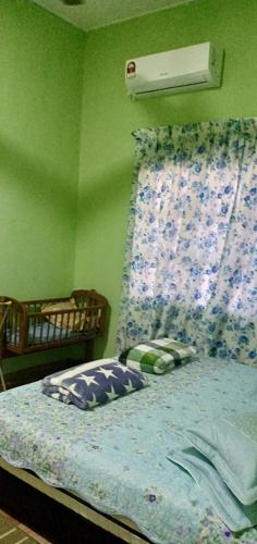 a bedroom with a bed with a flowered bedspread at Homestay Langkawi Airport in Kampung Padang Masirat