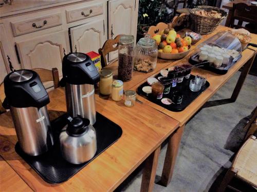 Una mesa de cocina con dos máquinas de café encima. en AUBERGE GAILLARD, en La Motte-en-Champsaur