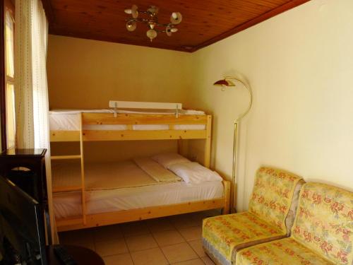 een slaapkamer met 2 stapelbedden en een stoel bij Villa Karanti in Limenas