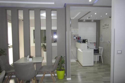 a room with a table and chairs and a kitchen at Freddy's Hotel in Tirana