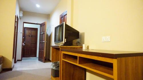 a living room with a tv and a counter with a table at Baron Water Front in Kuah