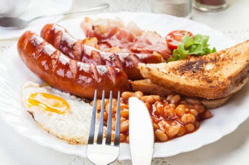 a plate of breakfast food with sausage beans and toast at Beach Corridor Hotel & Spa with Free Airport shuttle in Negombo