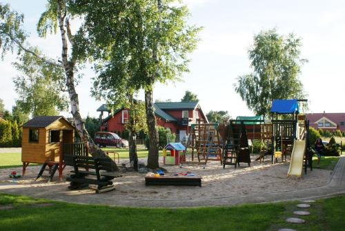 einen Park mit Spielplatz mit Rutsche und Baum in der Unterkunft Barwy Morza - domki in Rowy