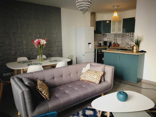 uma sala de estar com um sofá e mesas e uma cozinha em New and Luxury apartment Disneyland Paris em Serris