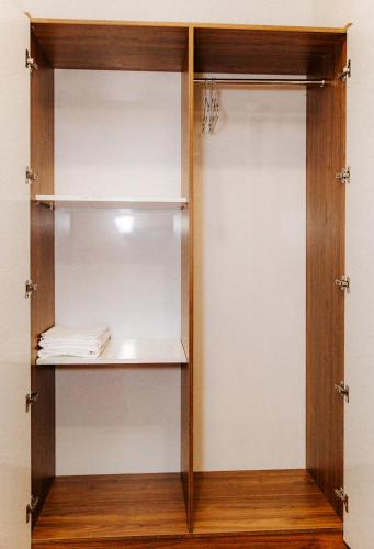 a closet with a wooden door and shelves at Tre Việt Tuy Hòa Hotel in Tuy Hoa