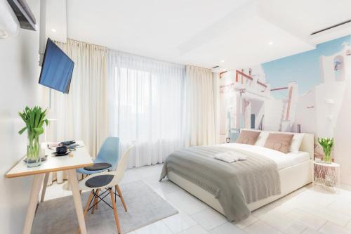 a white bedroom with a bed and a desk and a table at VISIONAPARTMENTS Baarerstrasse - contactless check-in in Zug