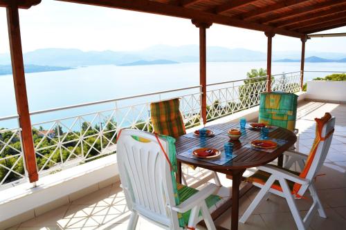 a table and chairs on a balcony with a view of the water at Villa View-Topia in Theológos
