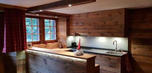 a kitchen with wooden walls and a counter with a sink at Chalet le Grenier - Romantique et exclusif in Champéry