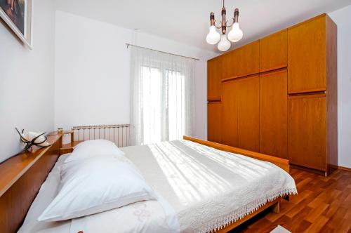 Schlafzimmer mit einem großen Bett mit einem Kopfteil aus Holz in der Unterkunft Apartment Ivo in Rovinj