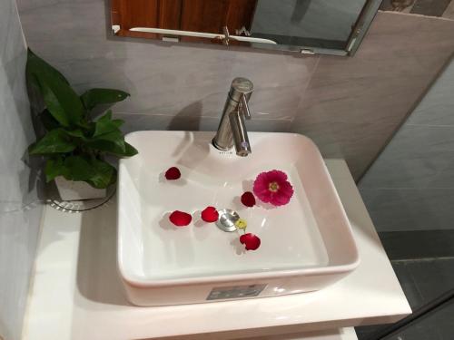 un lavandino in bagno con un fiore di Little Library Villa Hoi An a Hoi An