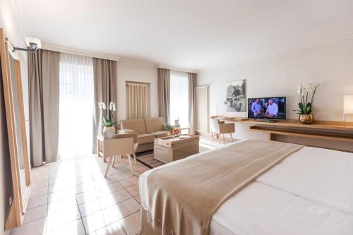a hotel room with a bed and a living room at Villa Favorita - Parkhotel Delta in Ascona