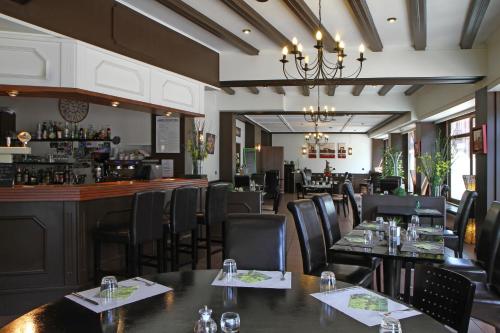 un restaurante con mesas y sillas y un bar en Hotel Champ Alsace, en Haguenau