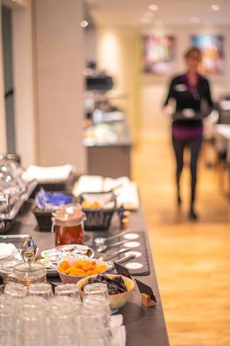 a counter with bowls of food on top of it at Sorell Hotel Rex in Zürich