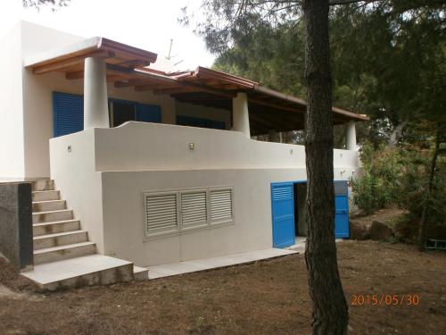 a white house with blue doors and stairs at Ustica Mari e Carlo Contrada Ogliastrello in Ustica