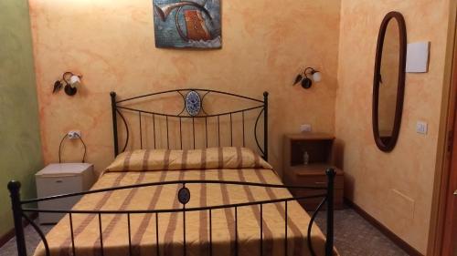 a bedroom with a black bed and two mirrors at Palazzo Aprile in Caltagirone