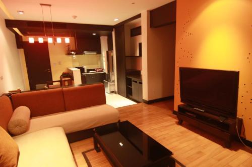 a living room with a couch and a flat screen tv at Room 6 pattaya tower in Pattaya