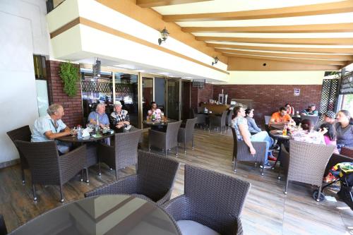 a group of people sitting at tables in a restaurant at Hotel Moldova in Bîrlad