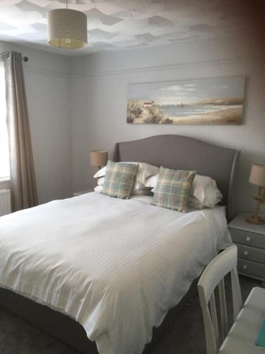 sypialnia z dużym białym łóżkiem z poduszkami w obiekcie Durlston House w mieście Lymington