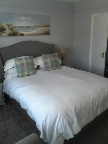 
a bed with a white comforter and pillows at Durlston House in Lymington
