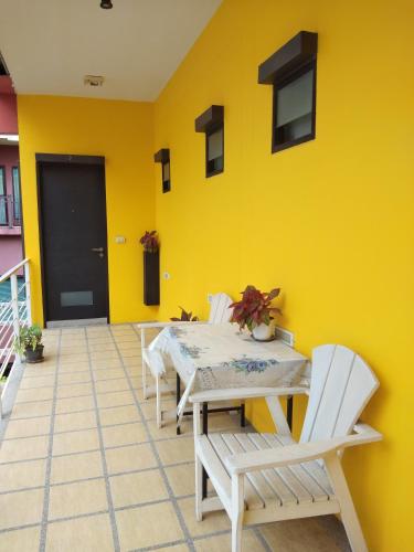 a room with a yellow wall with a table and chairs at room 5 pattaya tower in Pattaya