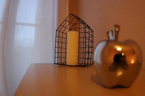 a candle and an apple on a table at L'Authentique - Situé en face des thermes et tout proche du coeur de ville in Rochefort