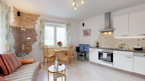 eine Küche und ein Wohnzimmer mit einem Sofa und einem Tisch in der Unterkunft Grünbergnahe Wohnung 45m2 und weißes Zimmer 17 m2 in Gmunden