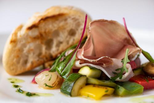 a plate of food with a sandwich and bread at La Contessa Castle Hotel in Szilvásvárad