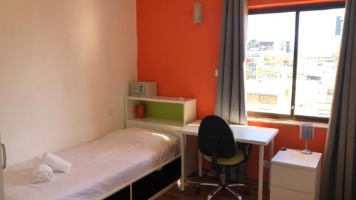 a small room with a bed and a desk and a window at City Living Suite Tk 3 Rm 4 in St Julian's