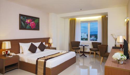 ein Hotelzimmer mit einem Bett, einem Tisch und Stühlen in der Unterkunft Sunrise Hotel in Tây Ninh