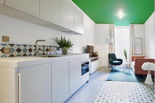 a kitchen with white cabinets and a green ceiling at L'Abeille - Boutique Apartments in Nice