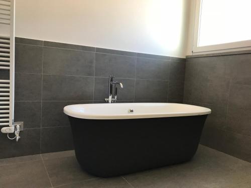 a bath tub with a faucet in a bathroom at nautilus b&b suite design in Follonica